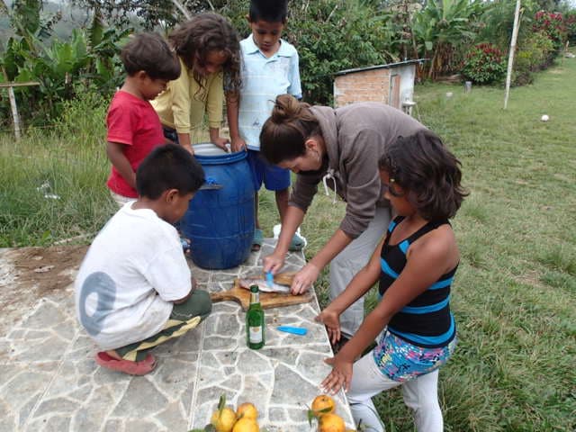Volunteerin bereitet mit Kindern der Umgebung Früchte zu